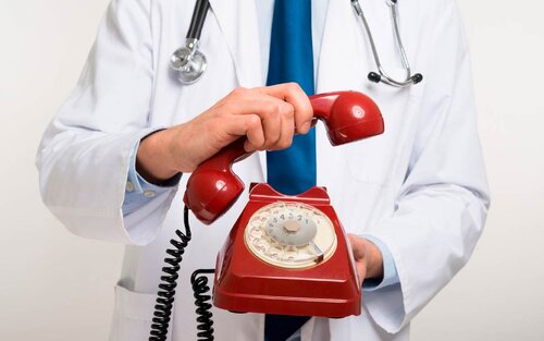 врач держит телефон 